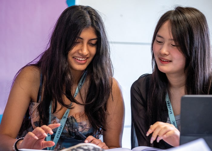 female-students-studing-on-laptop-smiling