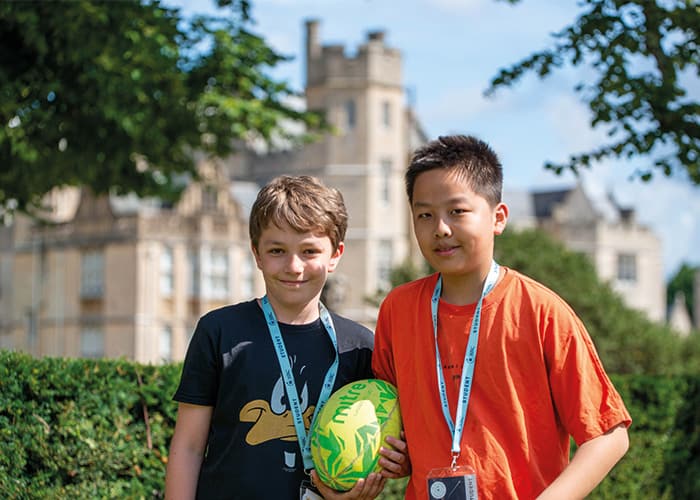 two-young-male-students-holding-rugby-ball-canford