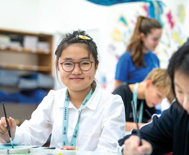 sbc-summer-student-smiling-holding-pen.