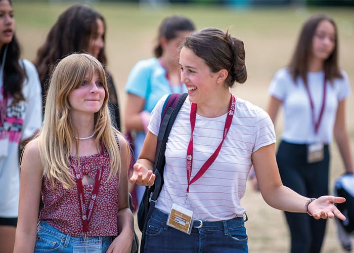 two-summer-school-friends-walking-and-laughing