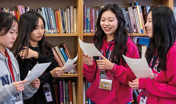 four-students-reading-in-library.