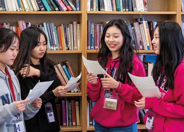 four-students-reading-in-library.