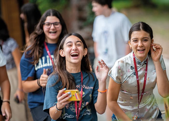 female-summer-school-students-walking-laughing.