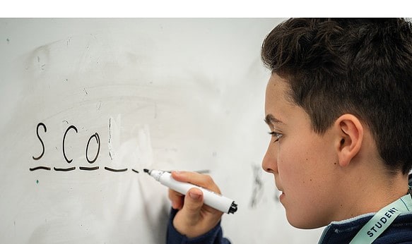 male-student-writing-on-whiteboard.j