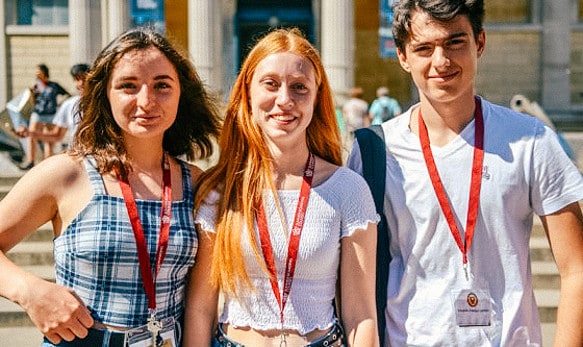 three-students-outside-on-a-trip-smiling