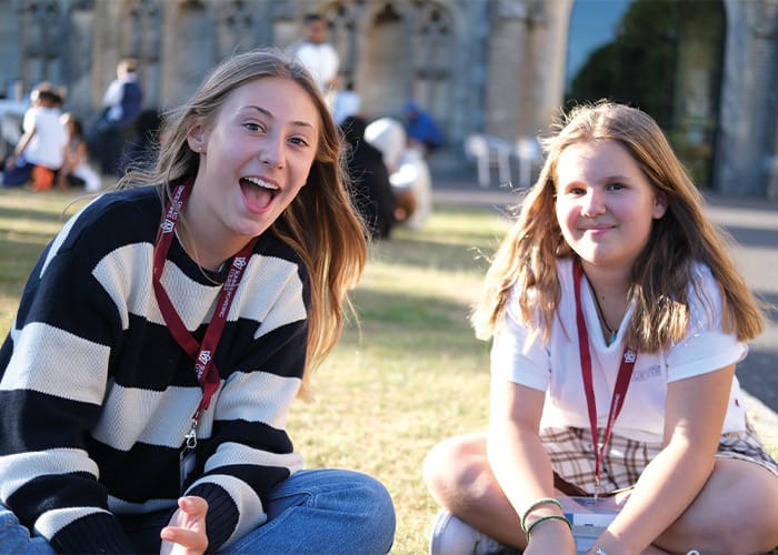 Canford-female-students-sat-down-smiling-summer.