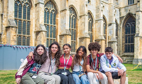 group-of-summer-school-students-smiling-in-front-of-building