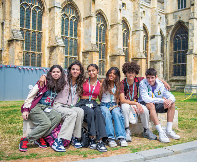 group-of-summer-school-students-smiling-in-front-of-building