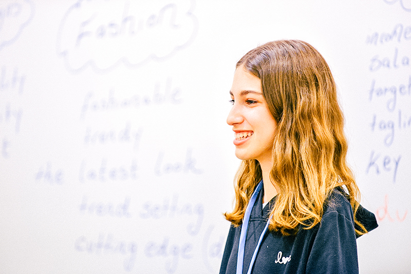 smiling student stood upfront
