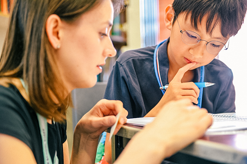 student and teacher working in a workbook