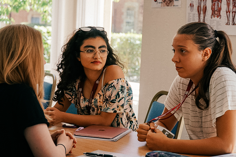 three students talking in a medicine class at oxford college
