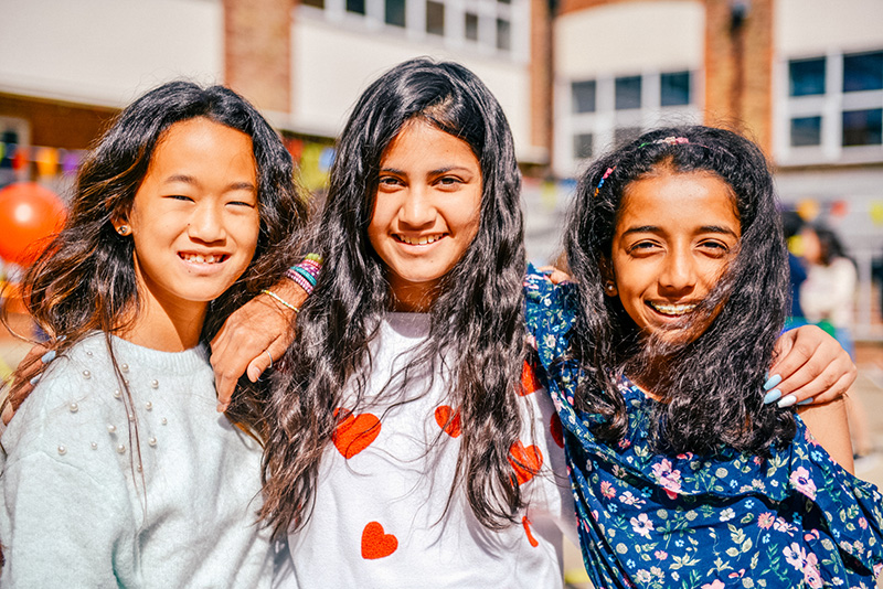 female students with their arms around each other outside lowres