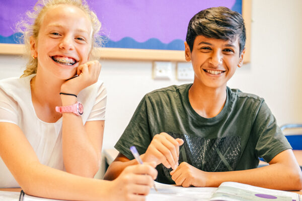 male and female student in classroom smiling together lowres