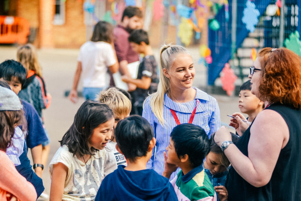 sbc oxford students stood around teachers at play time