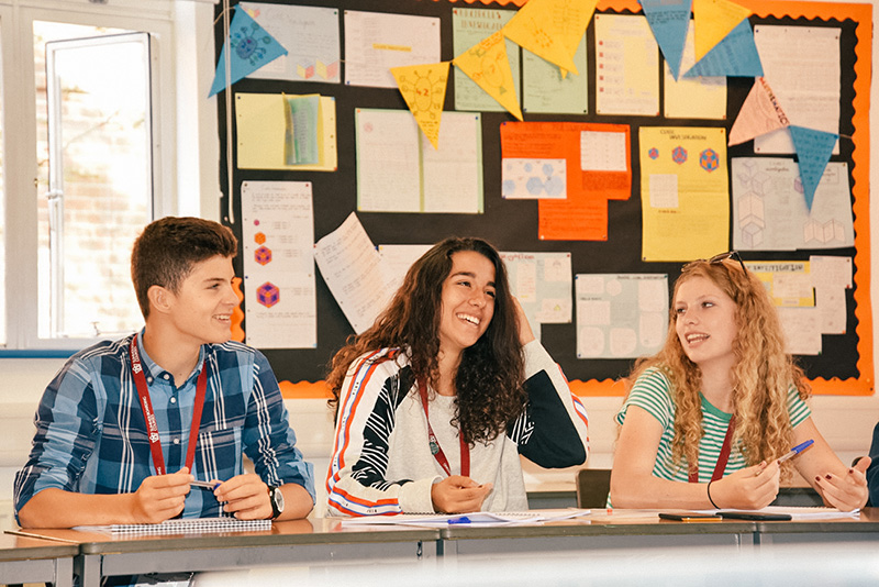 essay writing books for college students smiling students sat in classroom working lowres