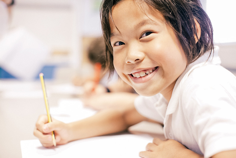 paragraph writing prompts grade 8 young smiling student writing in class lowres