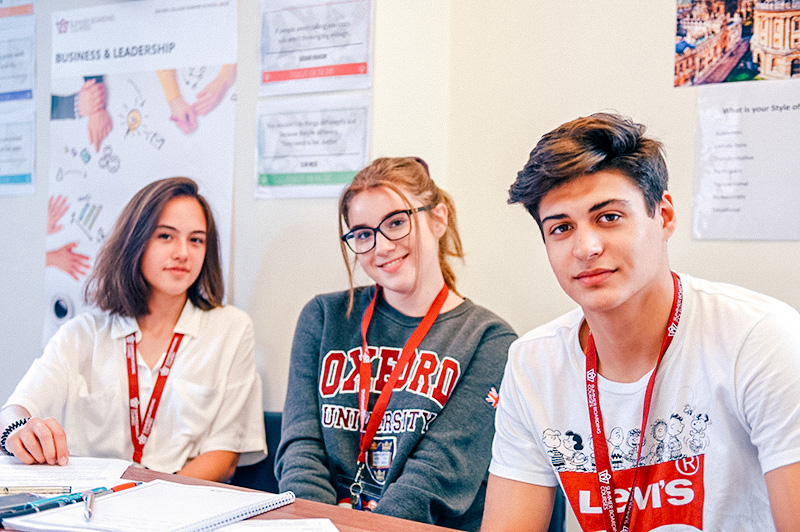 Three happy students in class together