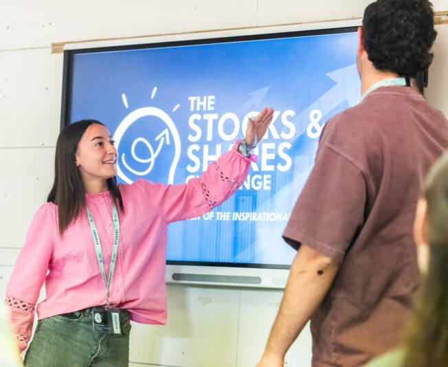 Summer boarding courses presentation with a young girl explaining on a digital screen.