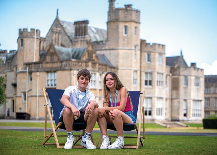 male-female-students-on-deckchairs-outside-summer-school