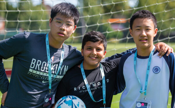 three-male-headington-students-smiling-in-football-net