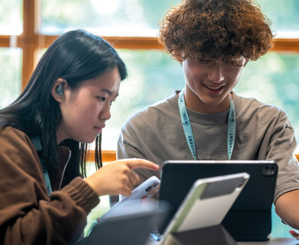 cambridge-college-psychology-students-smiling-using-ipad-in-summer-school-lesson