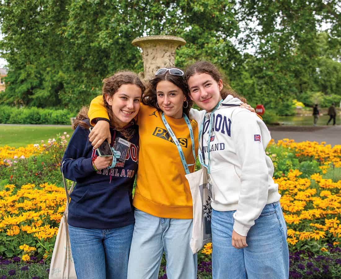 sbc-students-smilining-infront-of-flowerbed