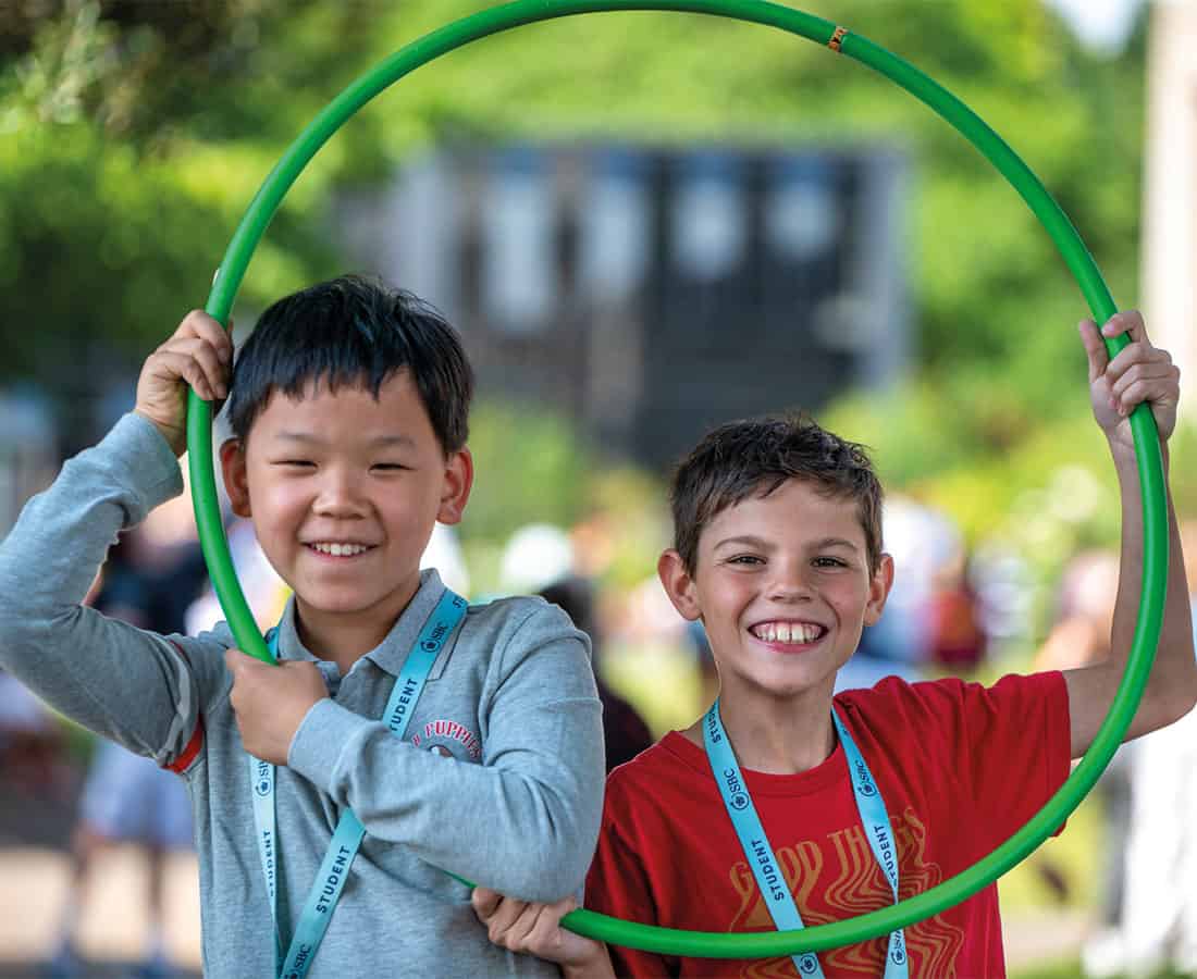 two-male-sbc-students-smiling-holding-hula-hoop