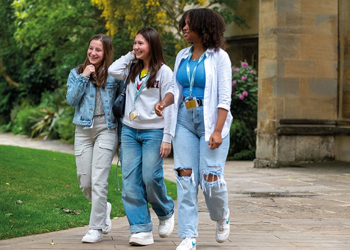 Three female Oxford College students smiling and walking through the grounds of Oxford College