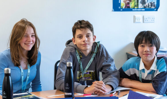 Happy students in the classroom at SBC Canford summer school all smiling and happy to be in the class together