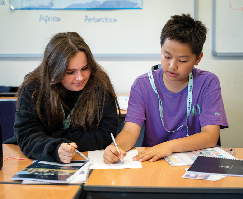 Male & Female student sat together in an Art & Design classroom at SBC Canford