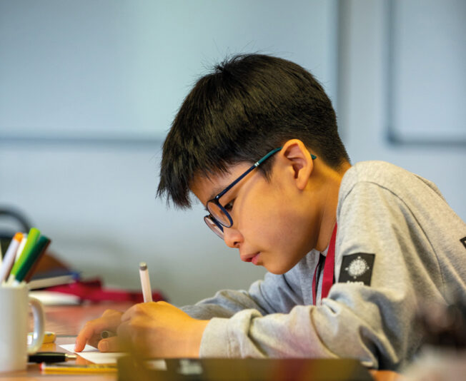 Male student using pens, doing some artwork in his SBC Canford Art class