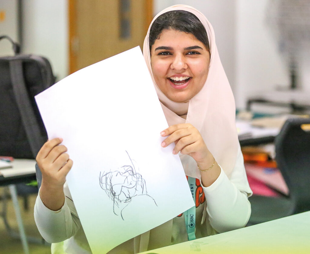 Art-student-holding-artwork-smiling