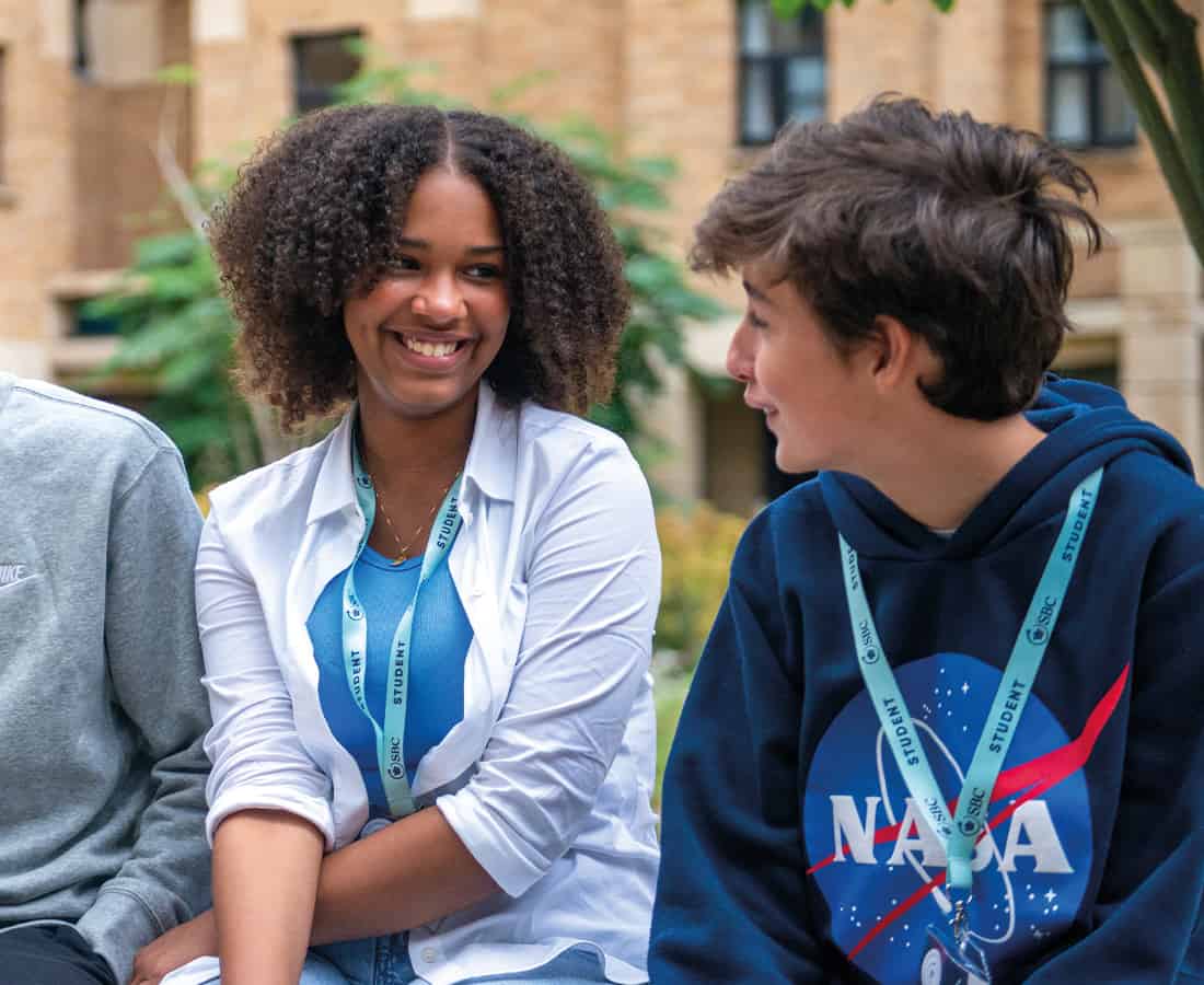 Smiling female student with two other students at Oxford College Summer Boarding Courses