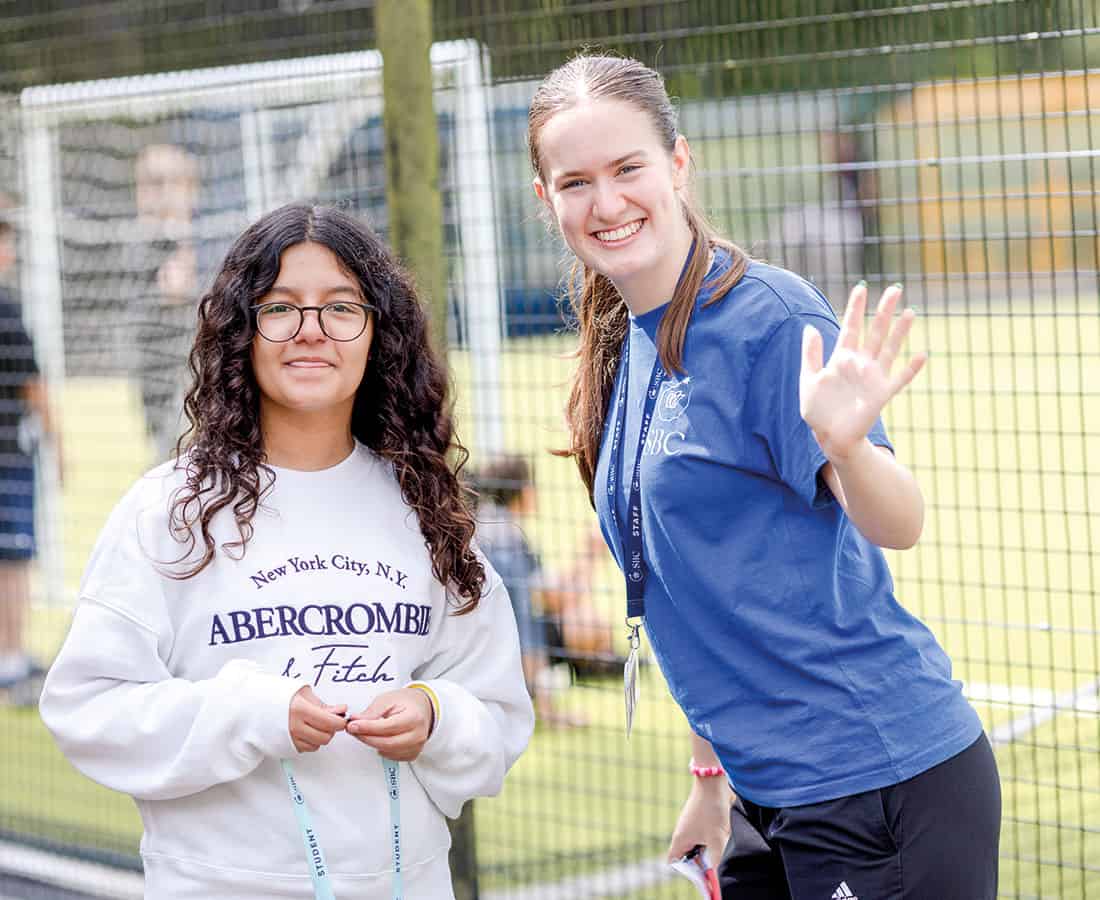 Student and summer school sports teacher smiling