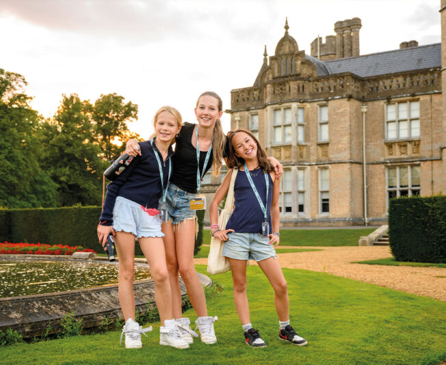 Three smiling SBC Canford students stood outside at Summer Boarding Courses