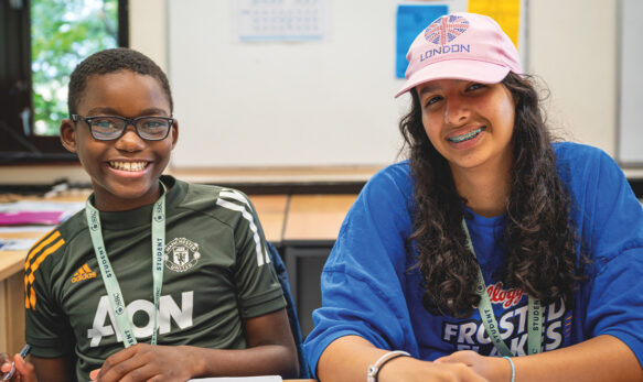 Two SBC Canford summer school students in the classroom together working together and smiling