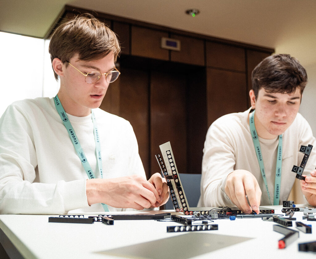 Two male students putting parts together as part of a Summer Boarding Courses classroom activity