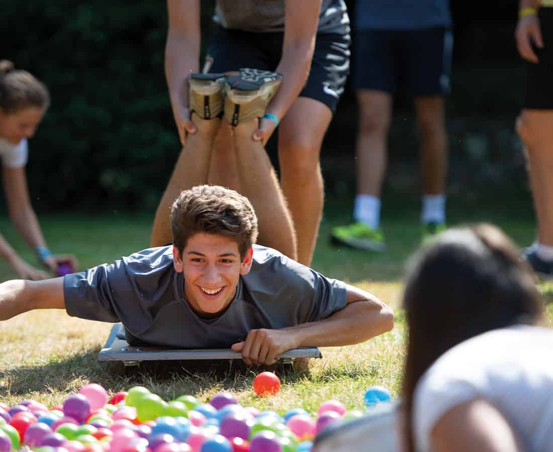 male-student-on-ground-ball-pit-summer-school-uk
