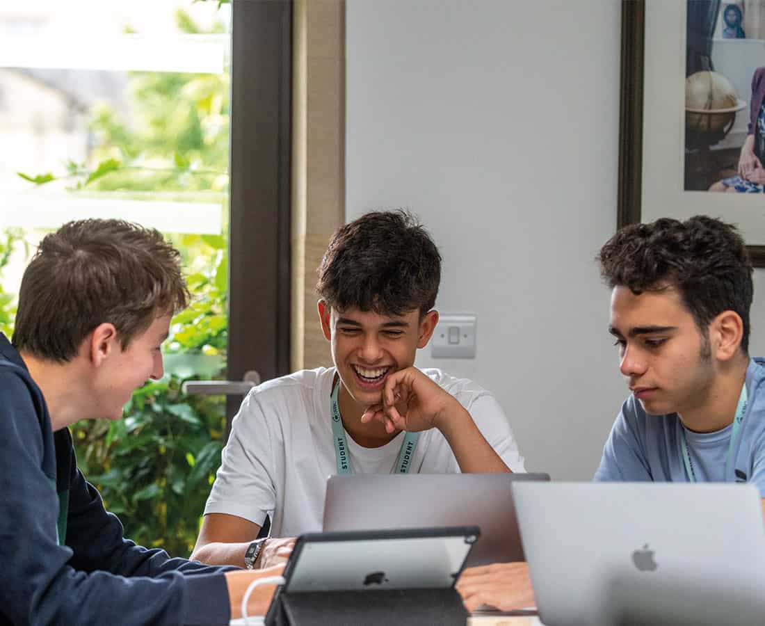 three-students-on-laptops-laughing-at-summer-camp