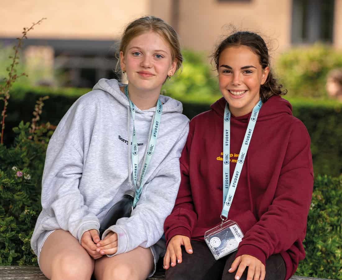 two-girls-sitting-outside-summer-school-smiling