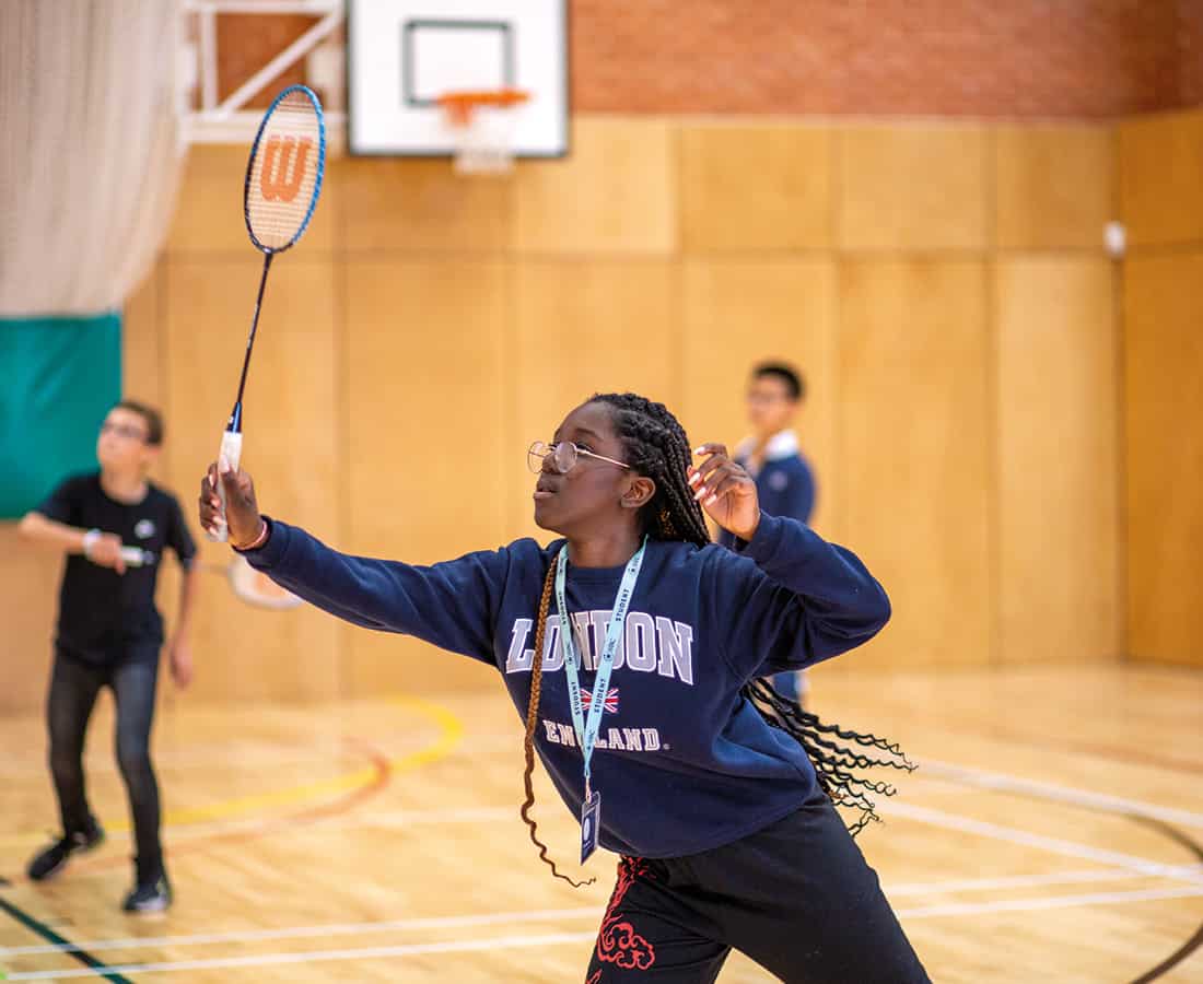 Female-Student-Playing-Badminton-in-a-sportshall-at-SBC-Eton-College-Summer-School