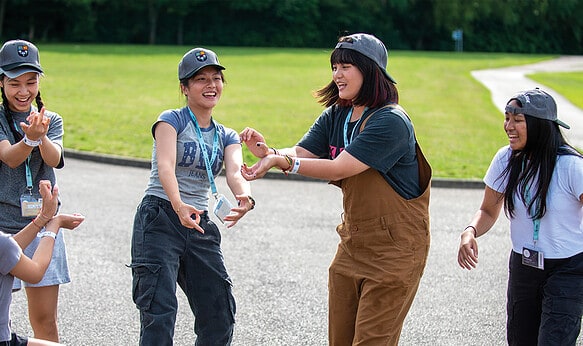 Five-female-students-dancing-outside-SBC-at-Eton-College-Summer-School