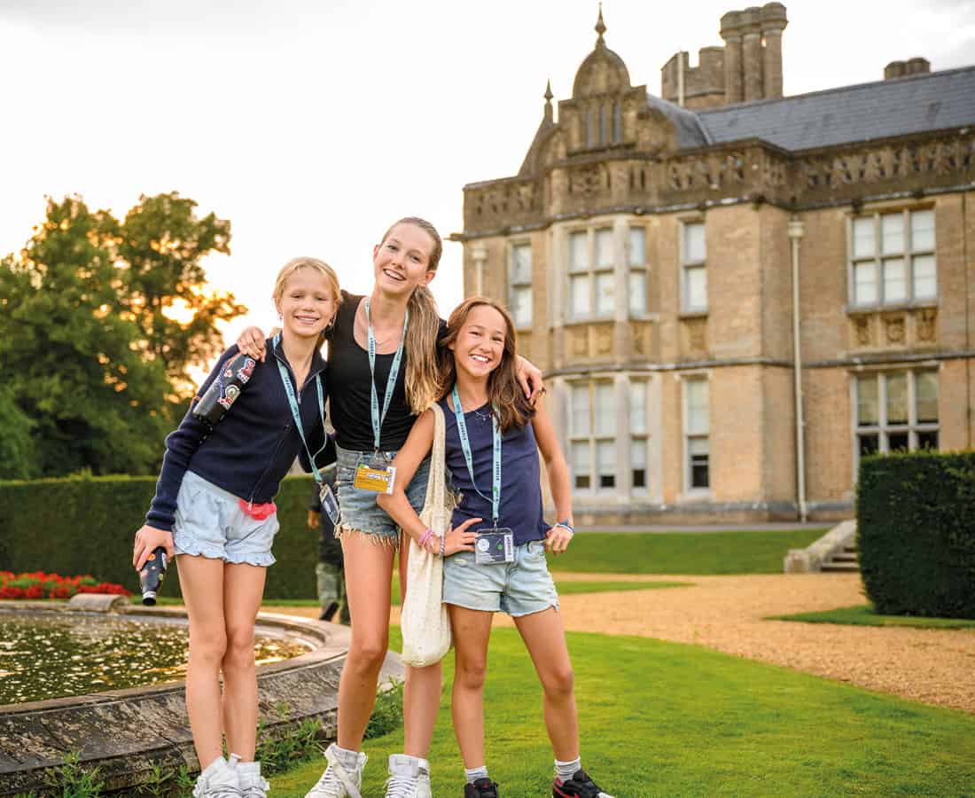 Three female SBC Canford students stood outside with their arms around each other smiling