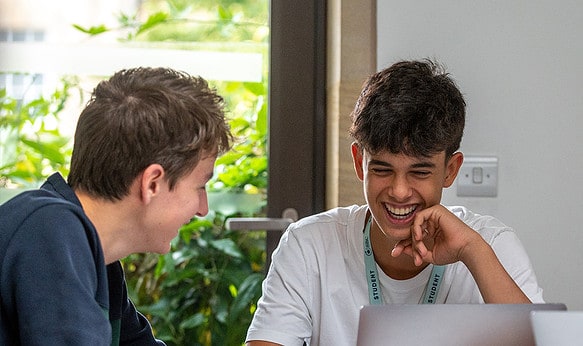 three-sbc-students-smiling-using-laptops-at-oxford-college