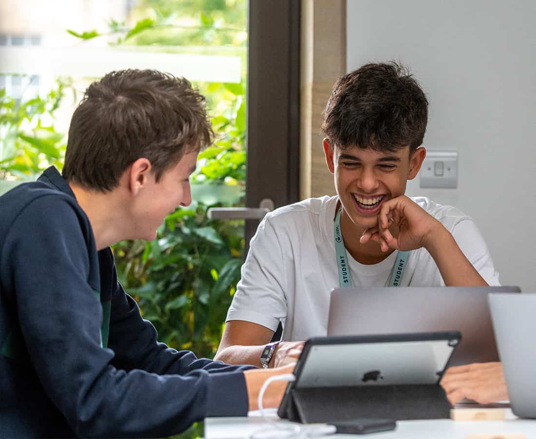 three-sbc-students-smiling-using-laptops-at-oxford-college