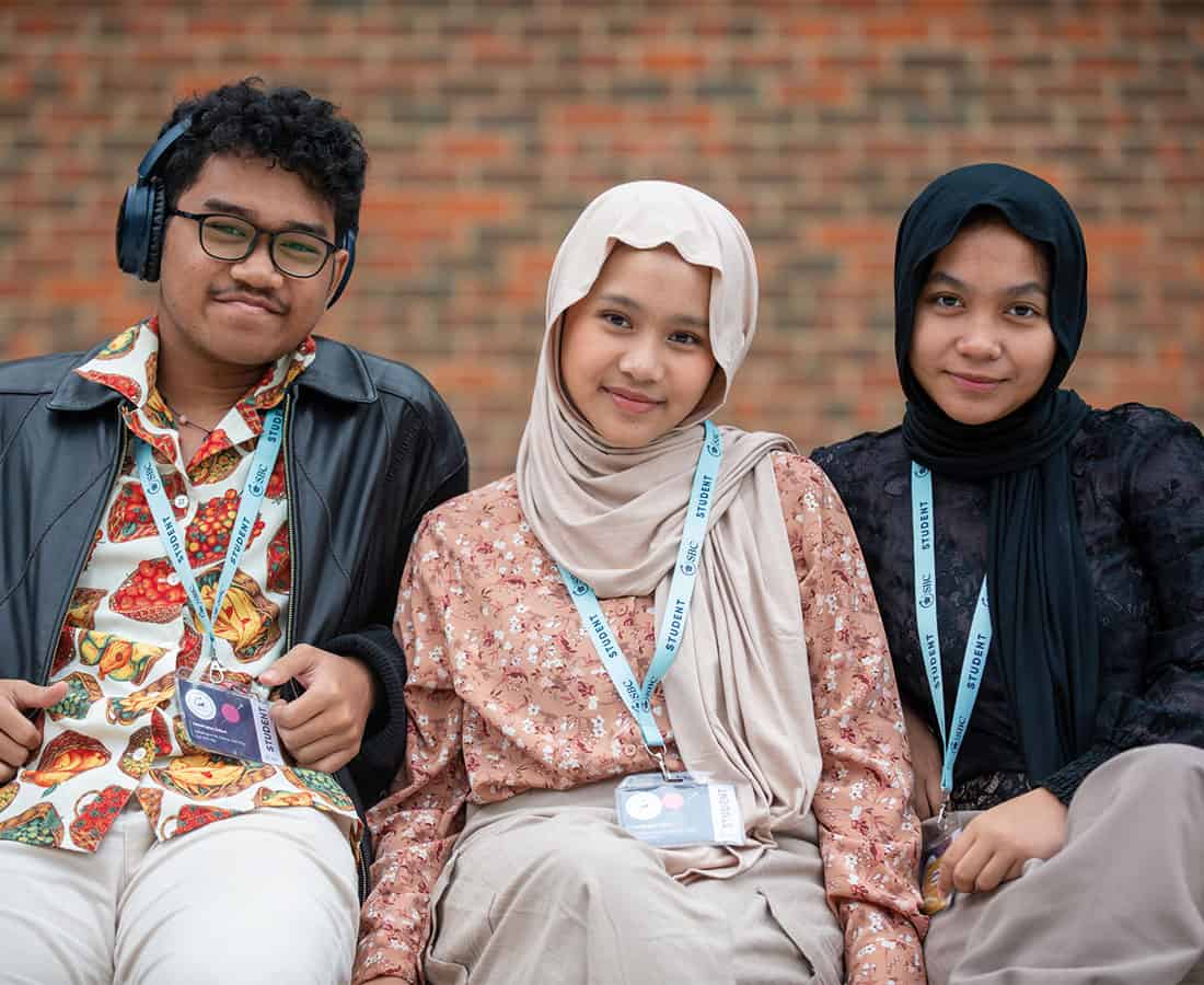three-sbc-students-smiling-wearing-headphones