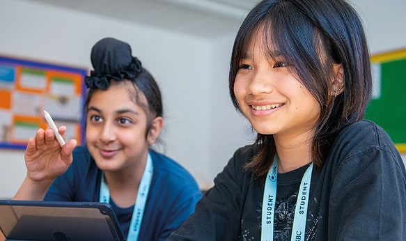 two-sbc-headington-students-smiling-using-laptop-