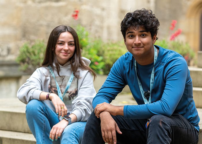 two-sbc-students-sat-on-steps-smiling