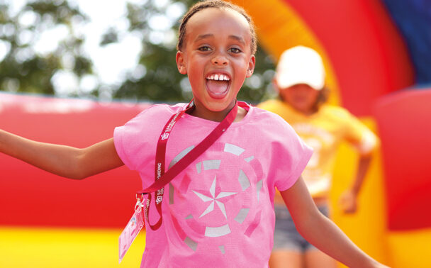 Female-Student-Smiling-at-Camp-Dragon-on-an-inflable-bouncey-castle