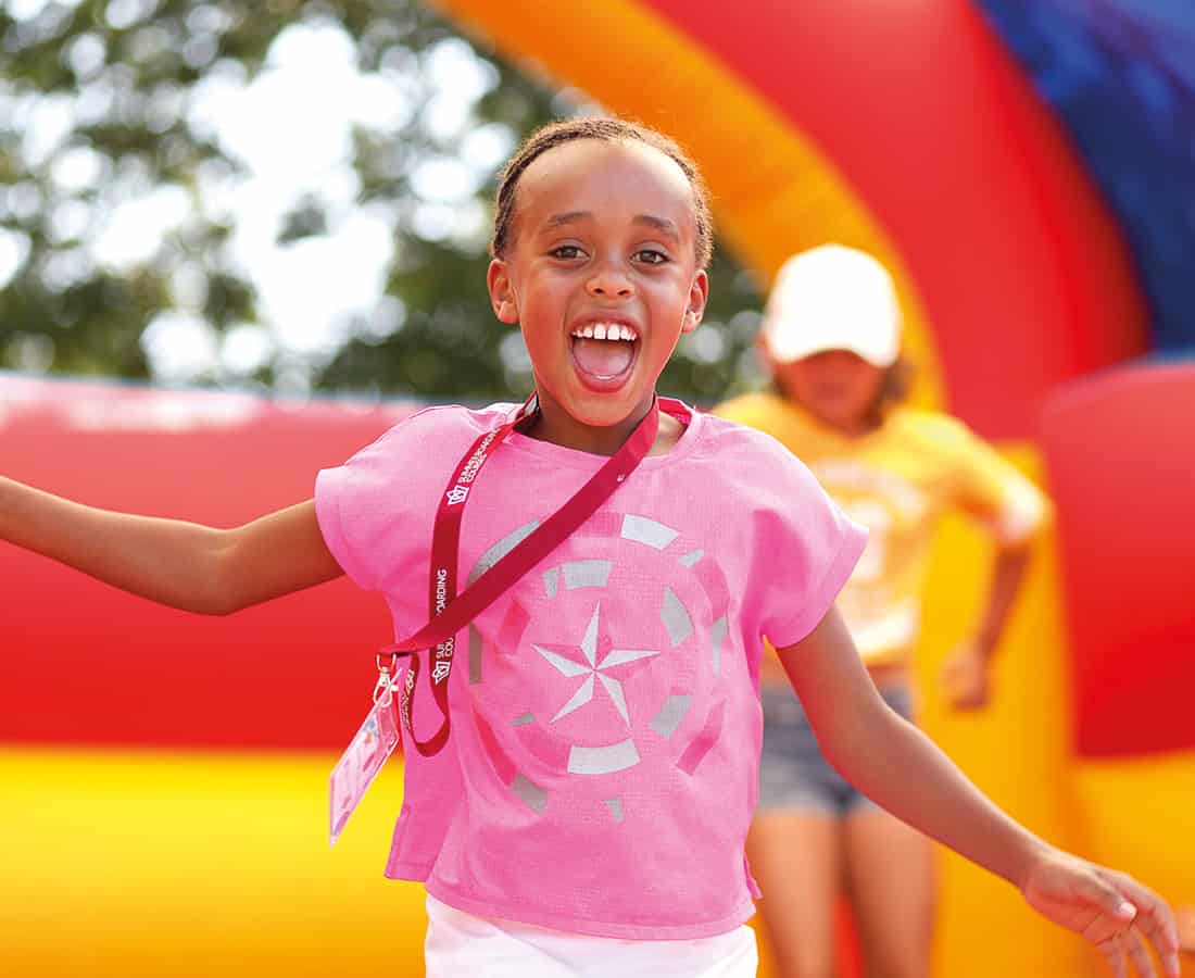 Female-Student-Smiling-at-Camp-Dragon-on-an-inflable-bouncey-castle